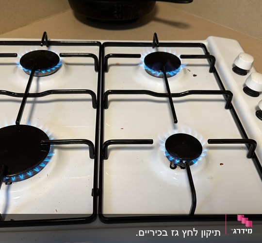 כיריים גז עם ארבעה מבערים דולקים